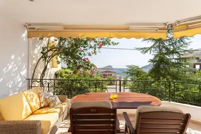 a patio with a table and chairs on a balcony at Kate's Beach Villa in Porto Rafti