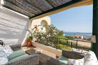 a balcony with a couch and a view of the ocean at Kate's Beach Villa in Porto Rafti