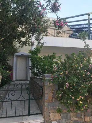 a building with a gate with flowers on it at Kate's Beach Villa in Porto Rafti