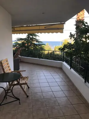 a balcony with a table and chairs and a view at Kate's Beach Villa in Porto Rafti