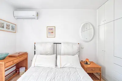 a bedroom with a bed and a clock on the wall at Kate's Beach Villa in Porto Rafti