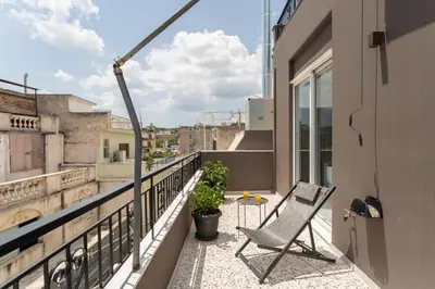 a chair on the balcony of a building at Downtown Boutique Apartments Acropolis View in Athens