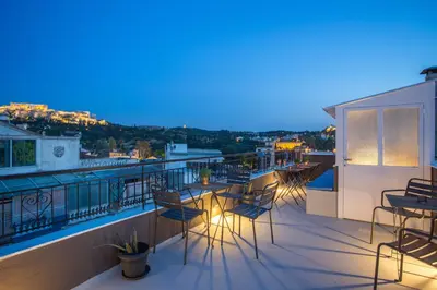a balcony with chairs and tables on a building at Downtown Boutique Apartments Acropolis View in Athens