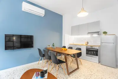 a kitchen with a wooden table and black chairs at Downtown Boutique Apartments Acropolis View in Athens