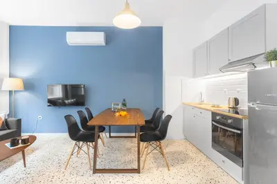 a kitchen with a wooden table and black chairs at Downtown Boutique Apartments Acropolis View in Athens