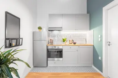 a kitchen with white cabinets and a refrigerator at Downtown Boutique Apartments Acropolis View in Athens