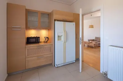 a kitchen with a refrigerator and a microwave at Rhea - Glyfada Sea View apartment in Athens