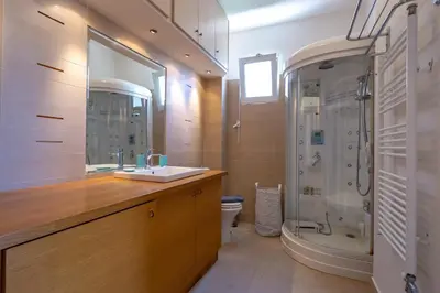 a bathroom with a sink and a shower and a toilet at Rhea - Glyfada Sea View apartment in Athens