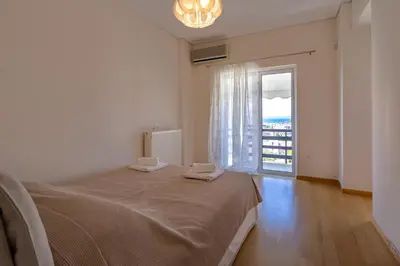 a bedroom with a bed and a large window at Rhea - Glyfada Sea View apartment in Athens