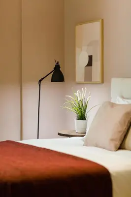 a bedroom with a bed with a lamp and a plant at Classy & Charming 1BD Apartment in Kolonaki by UPSTREET in Athens