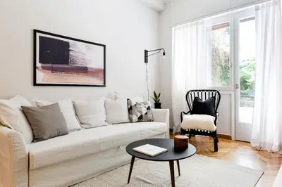 a white living room with a white couch and a table at Classy & Charming 1BD Apartment in Kolonaki by UPSTREET in Athens