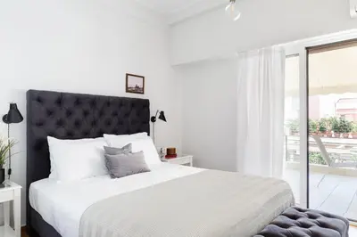 a white bedroom with a large bed and a window at Classy Luminous 1BD Apartment in Kolonaki by UPSTREET in Athens