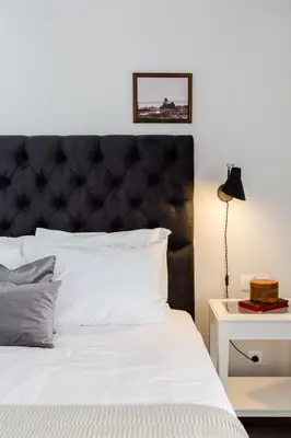 a bedroom with a white bed with a black headboard at Classy Luminous 1BD Apartment in Kolonaki by UPSTREET in Athens