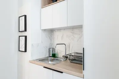 a kitchen with a sink and white cabinets at Classy Luminous 1BD Apartment in Kolonaki by UPSTREET in Athens