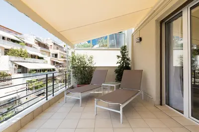 an apartment balcony with two chairs and windows at Classy Luminous 1BD Apartment in Kolonaki by UPSTREET in Athens