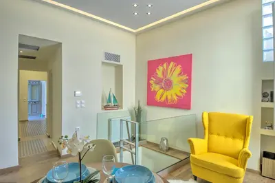a dining room with a glass table and a yellow chair at Stylish and cozy house in Athens, Plaka in Athens