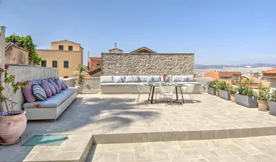 a patio with couches and a table on a building at Stylish and cozy house in Athens, Plaka in Athens