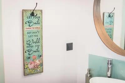 a bathroom with a sign on the wall next to a mirror at Athens Tower Boutique Apartment in Athens