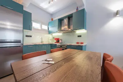 a kitchen with a wooden table and blue cabinets at Athens Tower Boutique Apartment in Athens