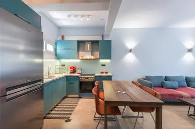 a kitchen with blue cabinets and a wooden table at Athens Tower Boutique Apartment in Athens