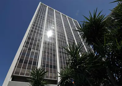 a tall building with palm trees in front of it at Athens Tower Boutique Apartment in Athens