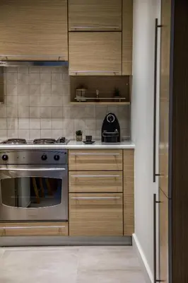 a kitchen with wooden cabinets and a stainless steel oven at Right under the Acropolis in Athens