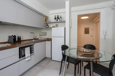 a kitchen with a glass table and black chairs at Unique Semi-Basement Stay at the Foot of the Acropolis in Athens