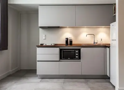 a kitchen with white cabinets and a microwave at Unique Semi-Basement Stay at the Foot of the Acropolis in Athens