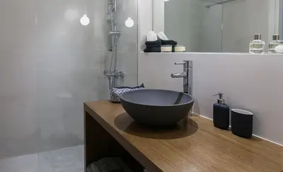 a bathroom with a large bowl sink on a wooden counter at Unique Semi-Basement Stay at the Foot of the Acropolis in Athens