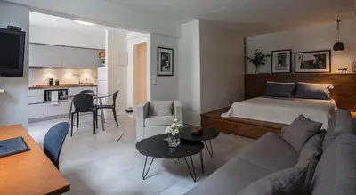 a living room with a couch and a bed and a kitchen at Unique Semi-Basement Stay at the Foot of the Acropolis in Athens