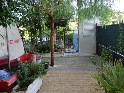 a walkway leading to a house with a tree at Artemis GreenHill in Vravrona