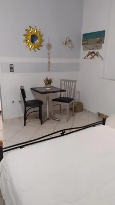 a bedroom with a table and chairs and a mirror at Artemis GreenHill in Vravrona