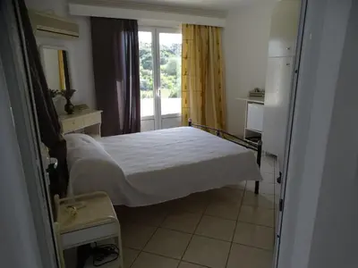 a small bedroom with a bed and a window at Artemis GreenHill in Vravrona