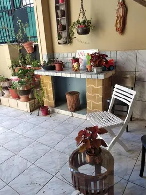 a patio with a chair and a table with potted plants at Artemis GreenHill in Vravrona