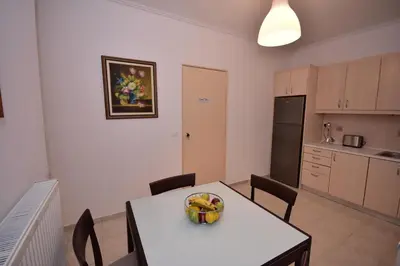 a kitchen with a table with a bowl of fruit on it at Keratea Apartment Athens Airport in Keratea