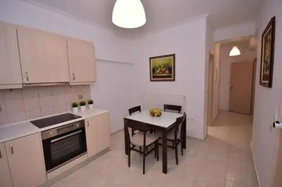 a kitchen with a table and chairs in a room at Keratea Apartment Athens Airport in Keratea