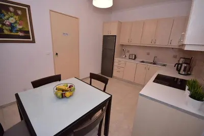 a kitchen with a bowl of fruit on a table at Keratea Apartment Athens Airport in Keratea