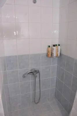 a shower with a shower head in a bathroom at Keratea Apartment Athens Airport in Keratea