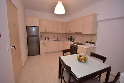 a kitchen with a table with a bowl of fruit on it at Keratea Apartment Athens Airport in Keratea