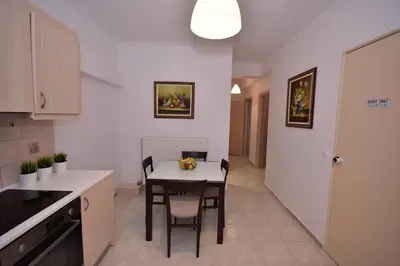 a kitchen with a table and chairs in a room at Keratea Apartment Athens Airport in Keratea