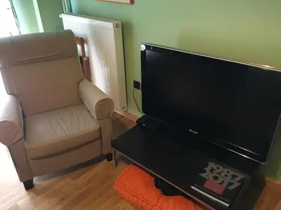 a living room with a chair and a large television at Cosy and comfort flat, heart of Athens in Athens