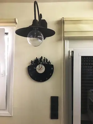 a clock hanging on a wall with a ceiling fan at Cosy and comfort flat, heart of Athens in Athens