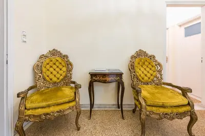 two chairs and a side table in a room at Victoria Queens Palace Apartments in Athens