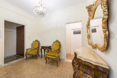 a room with a mirror and a table and chairs at Victoria Queens Palace Apartments in Athens