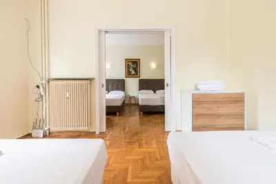 a bedroom with two beds and a room with two beds at Victoria Queens Palace Apartments in Athens