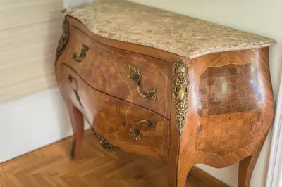 a wooden cabinet with a marble top on a wooden floor at Victoria Queens Palace Apartments in Athens