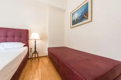a bedroom with a bed with a red head board at Victoria Familia Apartments in Athens