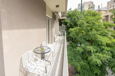 a balcony with a table and chairs on a building at Victoria Familia Apartments in Athens