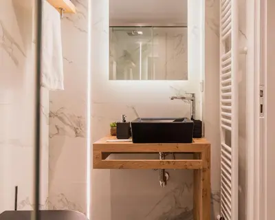 a bathroom with a sink and a mirror at Acropolis Luxury Living in Athens