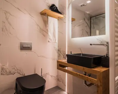 a bathroom with a black sink and a toilet at Acropolis Luxury Living in Athens
